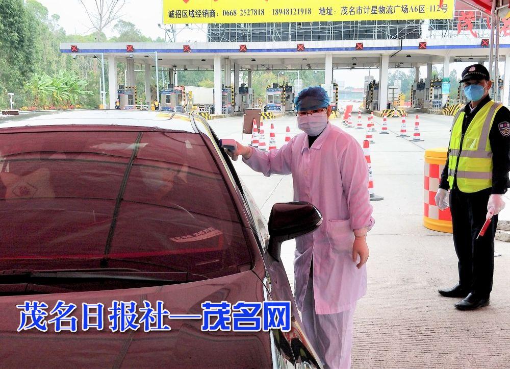 图为周水明在高速出入口为过往人员测量体温.jpg